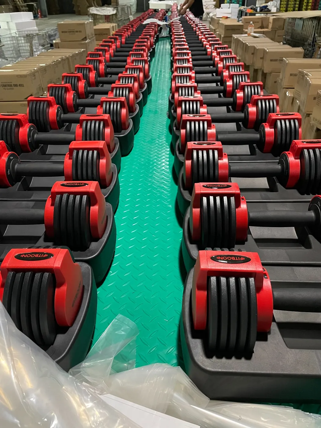 Red adjustable dumbbells on production line